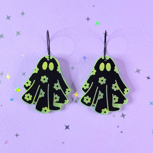 Acrylic earrings shaped like a blanket ghost covered in daisy flowers.