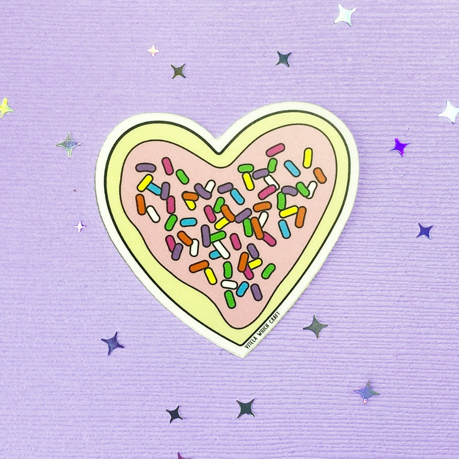Heart-shaped frosted sugar cookie with sprinkles sticker.