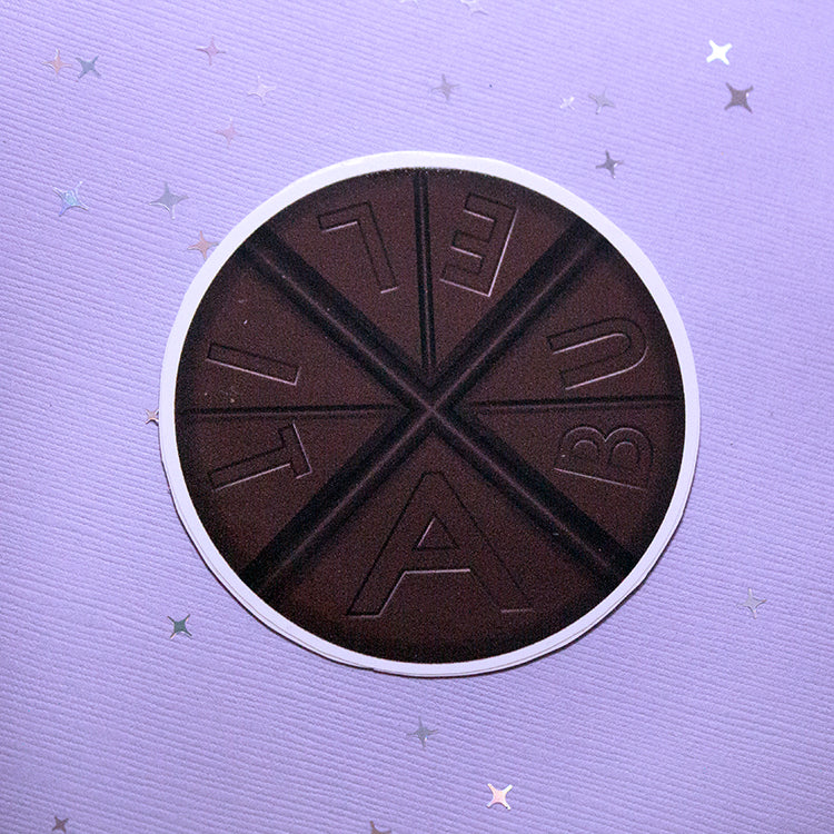 Round sticker shaped like Abuelita chocolate. 